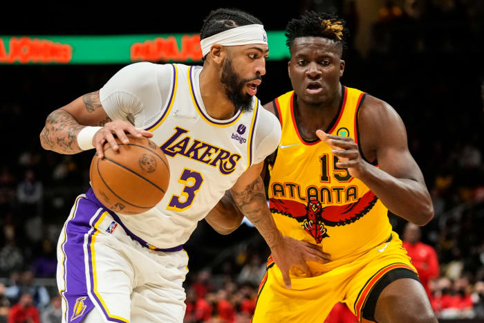 Los Angeles Lakers forward Anthony Davis controls the ball against Atlanta Hawks center Clint Capela. The two teams face off twice in the 2022-23 NBA season.